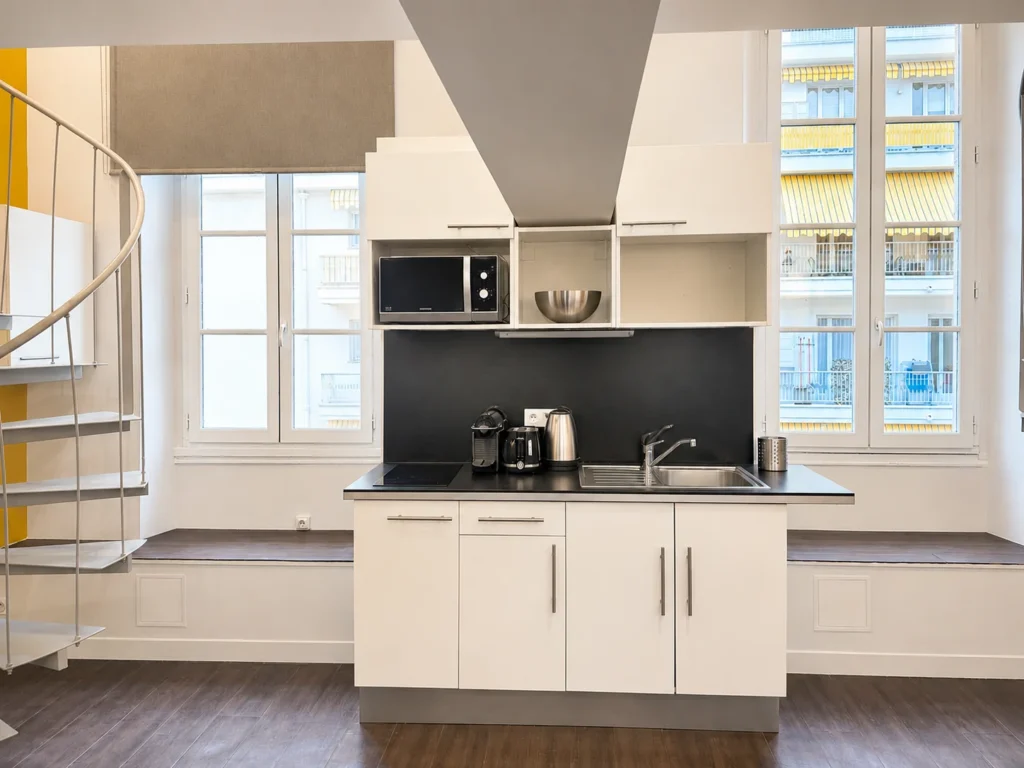 Cuisine équipée avec plaque de cuisson et vue sur les immeubles niçois – Grand Loft 3 Espaces, Carré d'Or Nice