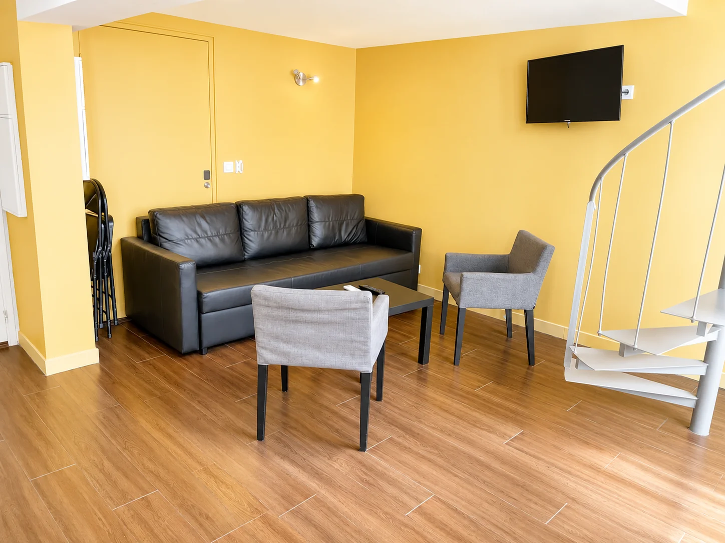 Salon avec canapé en cuir noir, fauteuils et TV murale – Grand Loft 3 Espaces, Carré d'Or Nice