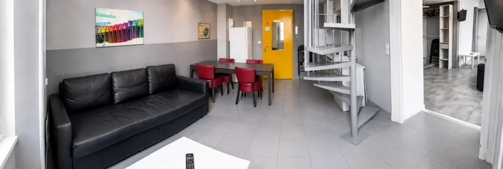 Vue d'ensemble du salon avec coin repas et escalier en colimaçon – Loft Confort, Carré d'Or Nice