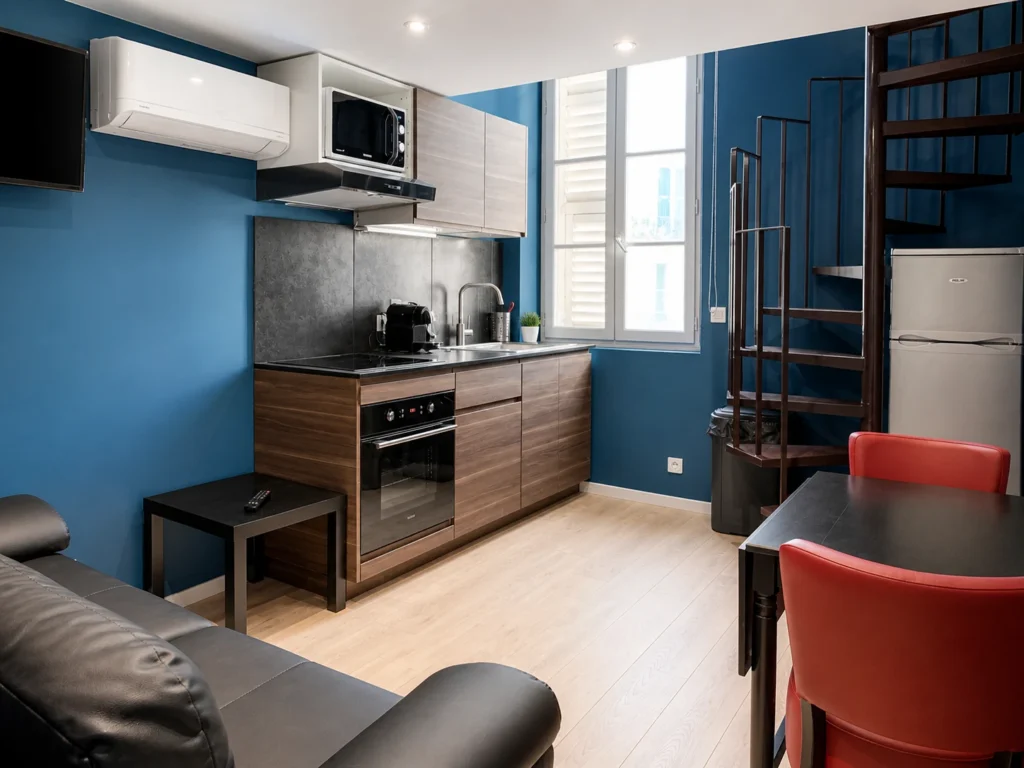 Vue d'ensemble de la cuisine et du salon avec escalier en colimaçon – Studio Cosy, Carré d'Or Nice