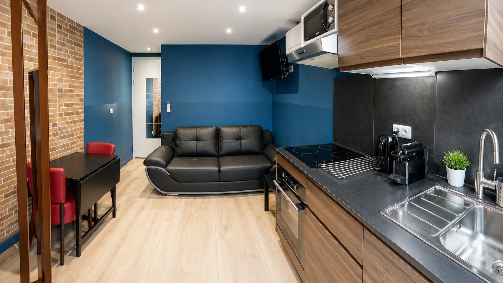 Salon ouvert sur la cuisine avec mur en briques – Studio Cosy, Carré d'Or Nice